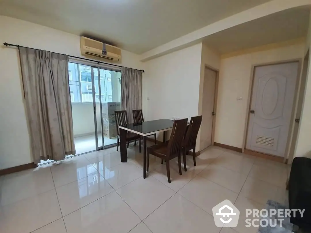 Spacious and well-lit living room with large windows, tiled flooring, and an elegant dining set, perfect for family gatherings.