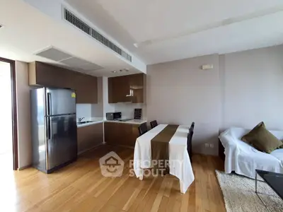 Modern kitchen and dining area with sleek cabinetry and wooden flooring in a stylish apartment.