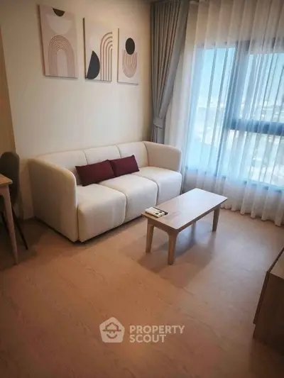Cozy living room with modern decor and natural light, featuring a stylish sofa and elegant curtains.