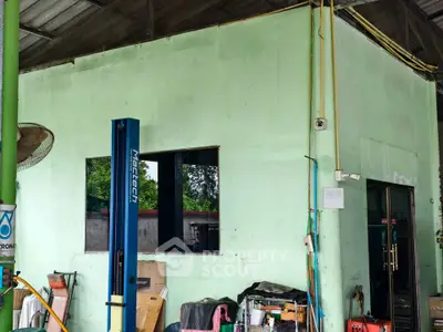 Industrial garage space with lift and tools, ideal for automotive work or storage.