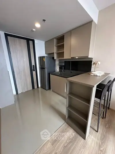 Modern kitchen with sleek cabinetry and breakfast bar in a stylish apartment.