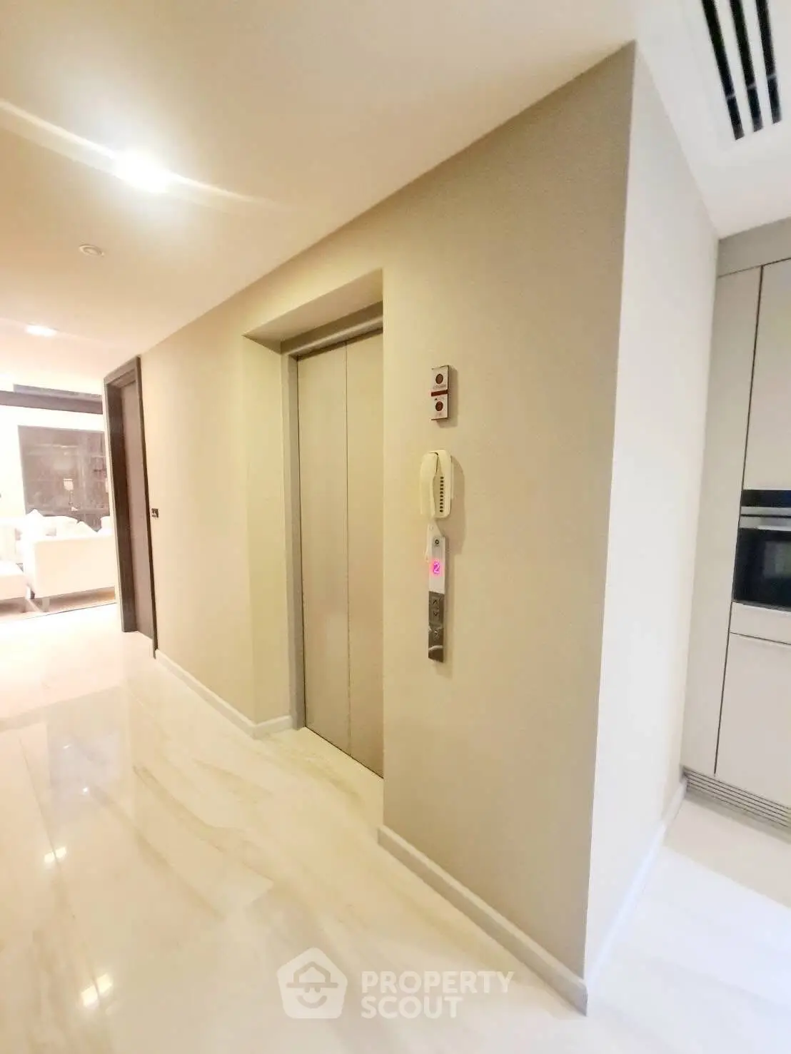 Modern apartment hallway with sleek elevator and marble flooring
