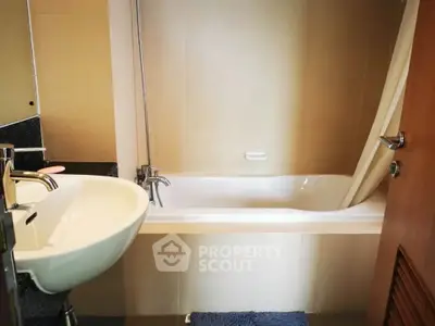 Modern bathroom with sleek sink and bathtub in a stylish apartment.