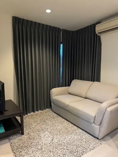 Cozy living room with modern sofa and elegant curtains, perfect for relaxation.