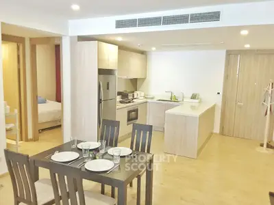 Modern open-plan kitchen and dining area with sleek wooden finishes and integrated appliances.