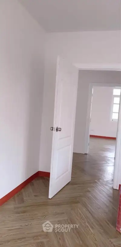 Spacious interior with open doors and wooden flooring, showcasing potential for customization.