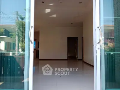 Spacious empty room with sliding glass doors and ample natural light.