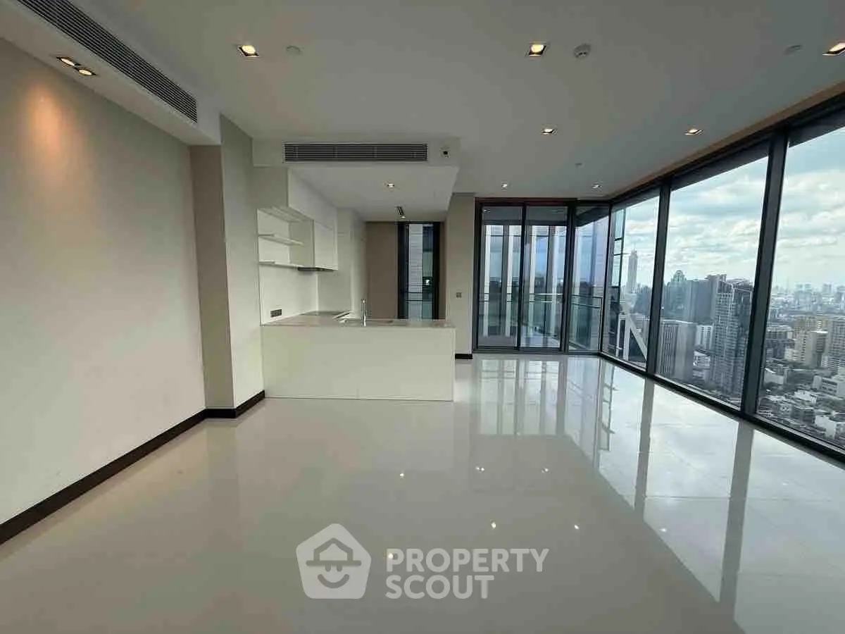 Spacious modern living room with panoramic city view and open kitchen layout.