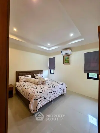 Spacious bedroom with modern decor and air conditioning in a stylish apartment.