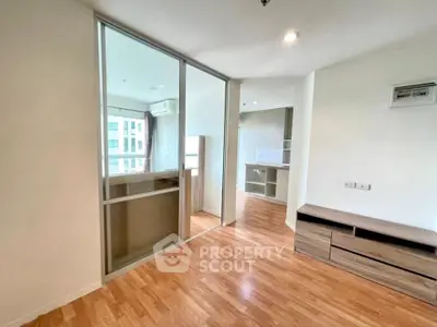 Spacious modern living room with wooden flooring and large windows in a stylish apartment.