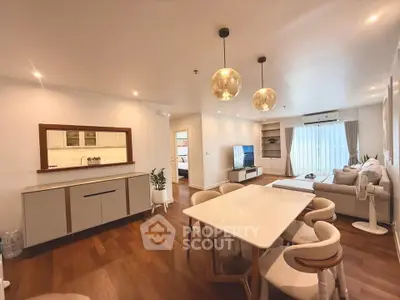 Spacious modern living room with elegant dining area and stylish lighting in a cozy apartment.