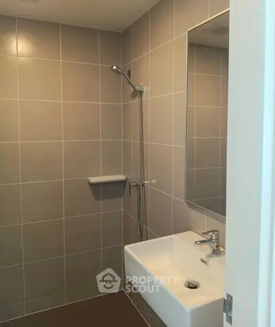 Modern bathroom with sleek tiles and minimalist fixtures, perfect for contemporary living.
