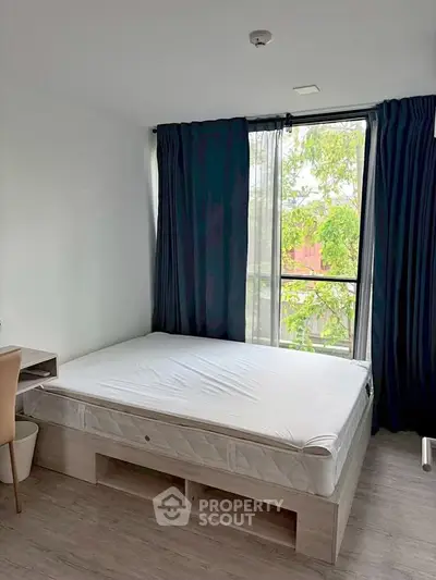 Bright bedroom with large window and modern furnishings, perfect for natural light lovers.