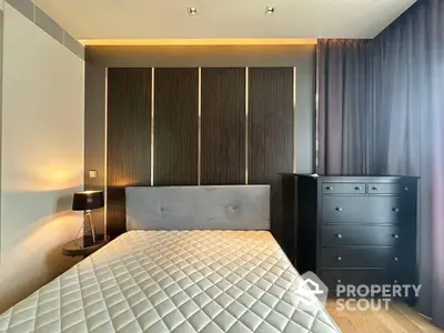 Elegant bedroom with a large comfortable bed, stylish wooden wardrobe, and modern dark furnishings, creating a cozy and sophisticated atmosphere.