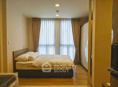 Cozy bedroom with large windows and elegant curtains in modern apartment