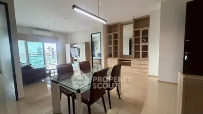 Spacious modern living room with dining area and city view, featuring sleek furniture and elegant design.