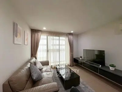 Modern living room with sleek TV setup and cozy leather sofa