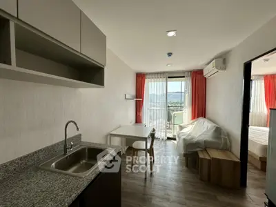 Modern studio apartment with kitchenette and mountain view, featuring sleek design and natural light.