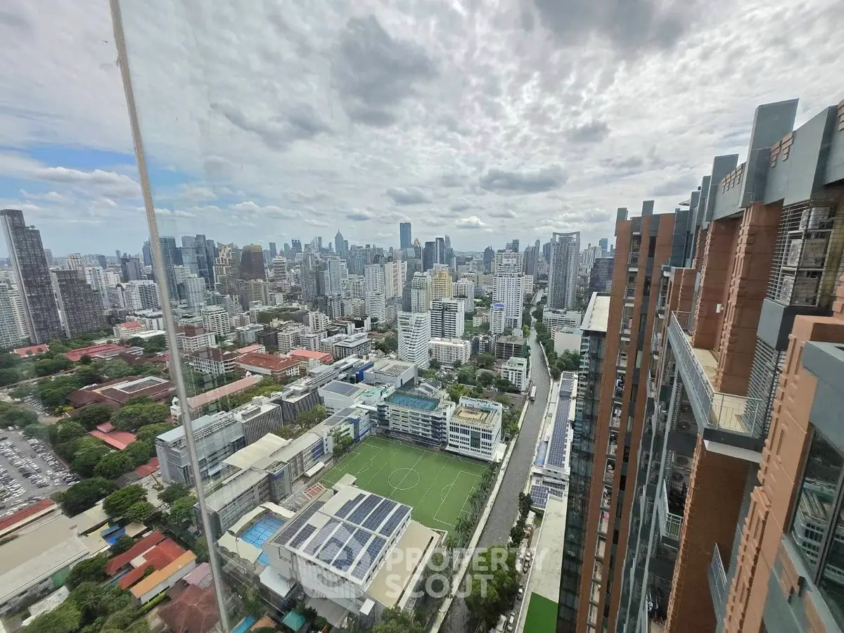 Stunning cityscape view from high-rise building showcasing urban skyline and green spaces.