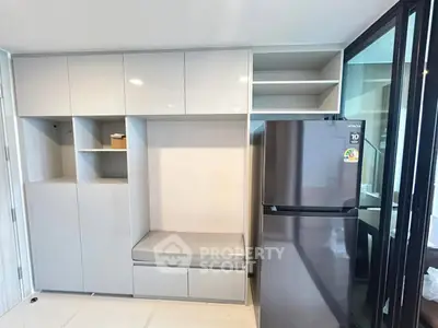 Modern kitchen with sleek cabinetry and stainless steel fridge in a stylish apartment.