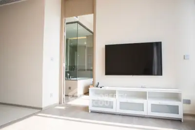 Modern living room with wall-mounted TV and sleek white cabinet