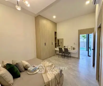 Spacious bedroom with modern decor and built-in wardrobe, featuring a cozy study nook and elegant lighting.