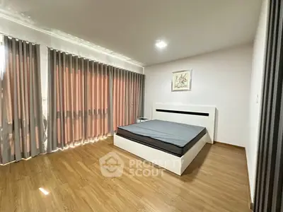 Spacious modern bedroom with large windows and elegant decor