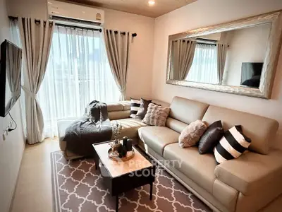 Stylish living room with cozy seating and large window offering natural light.