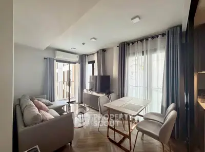 Modern living room with stylish furniture and natural light, featuring a cozy sofa and dining area.