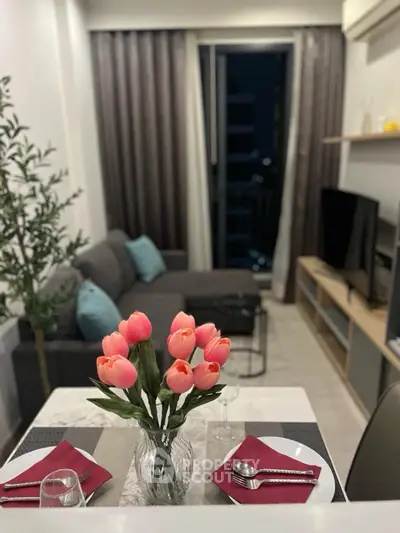 Modern living room with elegant decor and cozy ambiance, featuring a stylish sofa and vibrant tulip centerpiece.