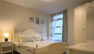 Charming bedroom with elegant decor and natural light, featuring a cozy bed and stylish wardrobe.