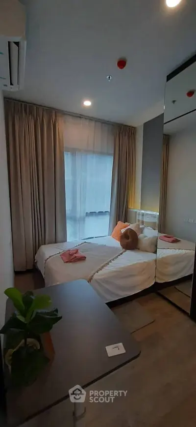 Cozy bedroom with large window and modern decor, perfect for relaxation and comfort.