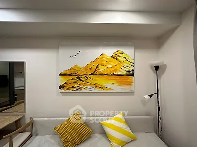 Modern living room with stylish decor and vibrant artwork, featuring cozy seating and elegant lighting.
