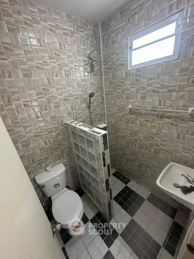 Compact bathroom with tiled walls and modern fixtures