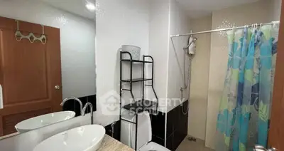 Modern bathroom with stylish sink and shower curtain in a cozy apartment.