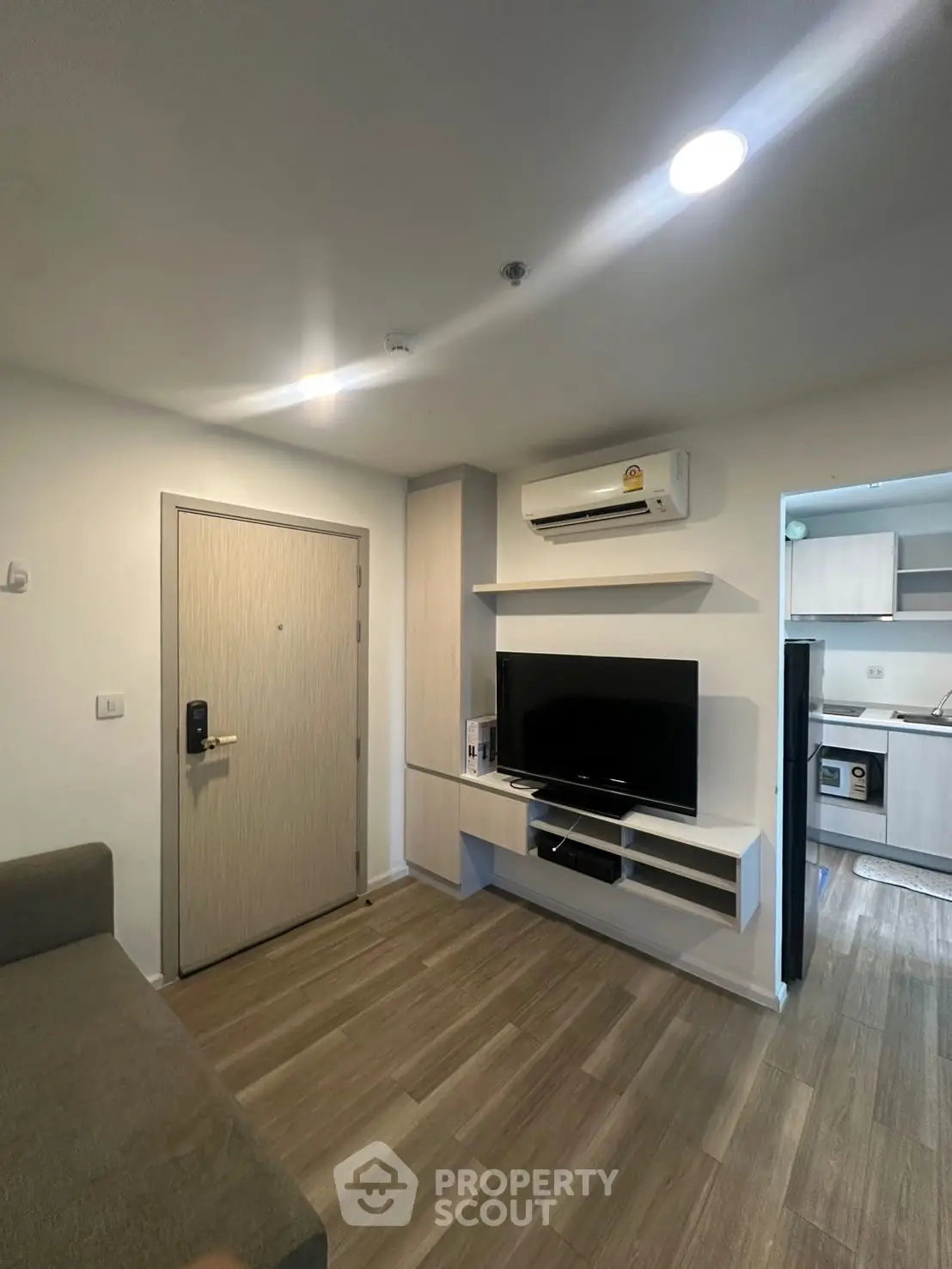 Modern living room with sleek TV setup and open kitchen view