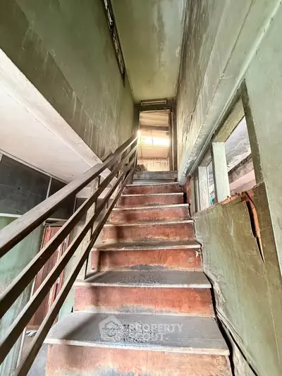 Explore potential in this fixer-upper with rustic staircase and natural light.