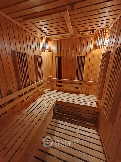 Luxurious wooden sauna with warm lighting and spacious seating