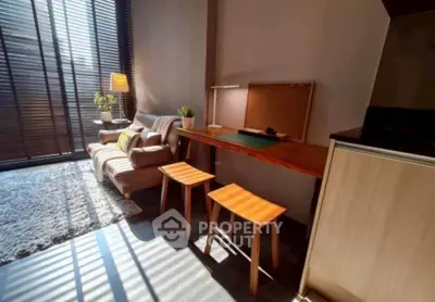 Modern living room with cozy seating and natural light, perfect for relaxation and work-from-home setup.