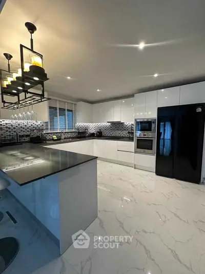 Modern kitchen with sleek white cabinets and stylish black appliances