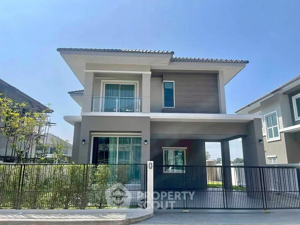 Modern two-story house with sleek design and spacious balcony in a serene neighborhood.