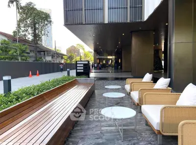 Luxurious modern building entrance with stylish outdoor seating area and elegant design.