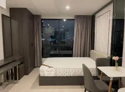 Modern bedroom with city view, stylish furniture, and elegant decor in a high-rise apartment.