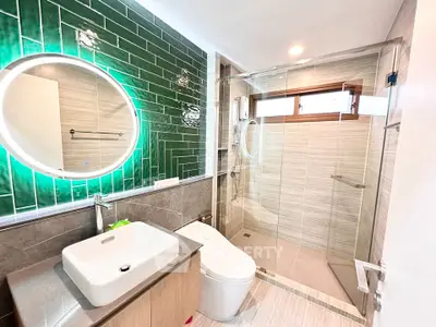 Modern bathroom with stylish green tiles and glass shower enclosure