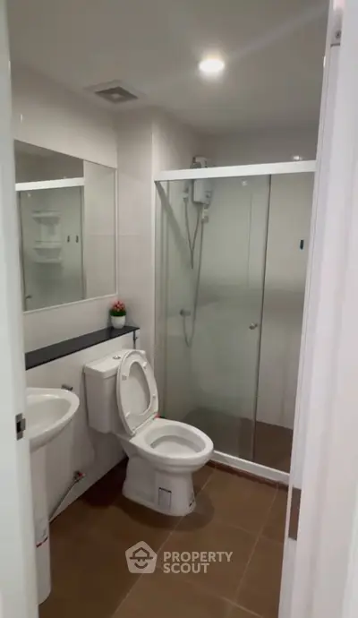 Modern bathroom with glass shower enclosure and sleek fixtures