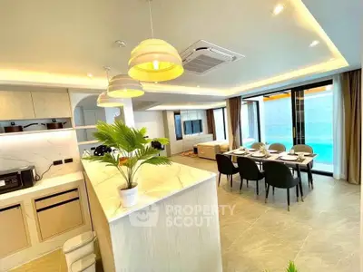 Luxurious open-plan living room with modern kitchen and pool view, perfect for entertaining.