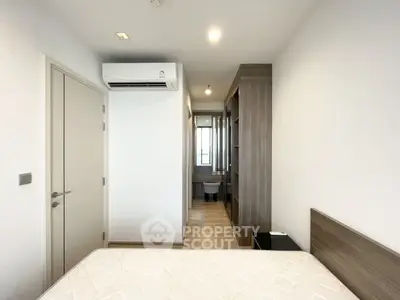 Modern bedroom with air conditioning and ensuite bathroom in a stylish apartment.