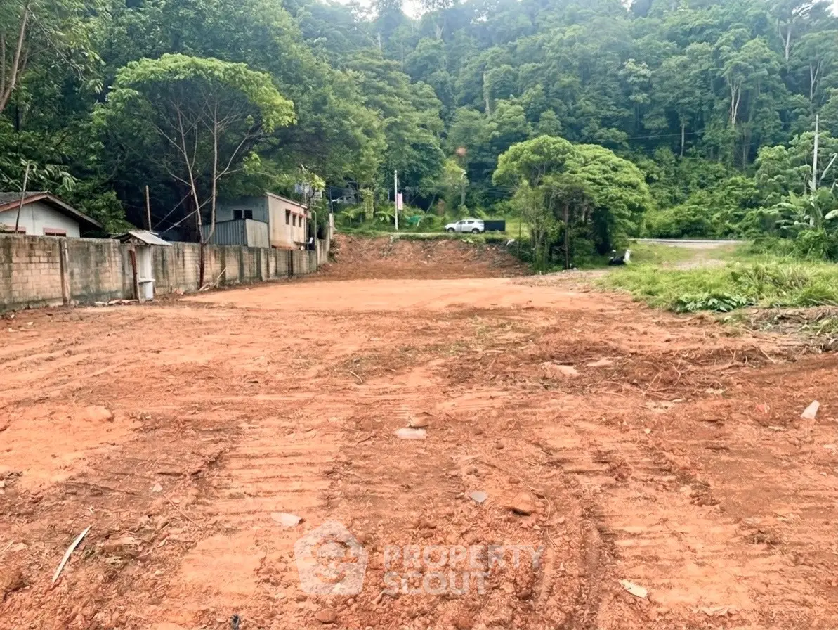Spacious land plot surrounded by lush greenery, ideal for development or investment opportunities.