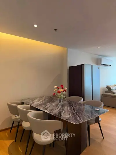 Modern dining area with elegant marble table and stylish chairs in a cozy living space.