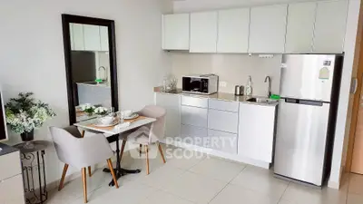 Modern kitchen with sleek cabinets and dining area in stylish apartment.